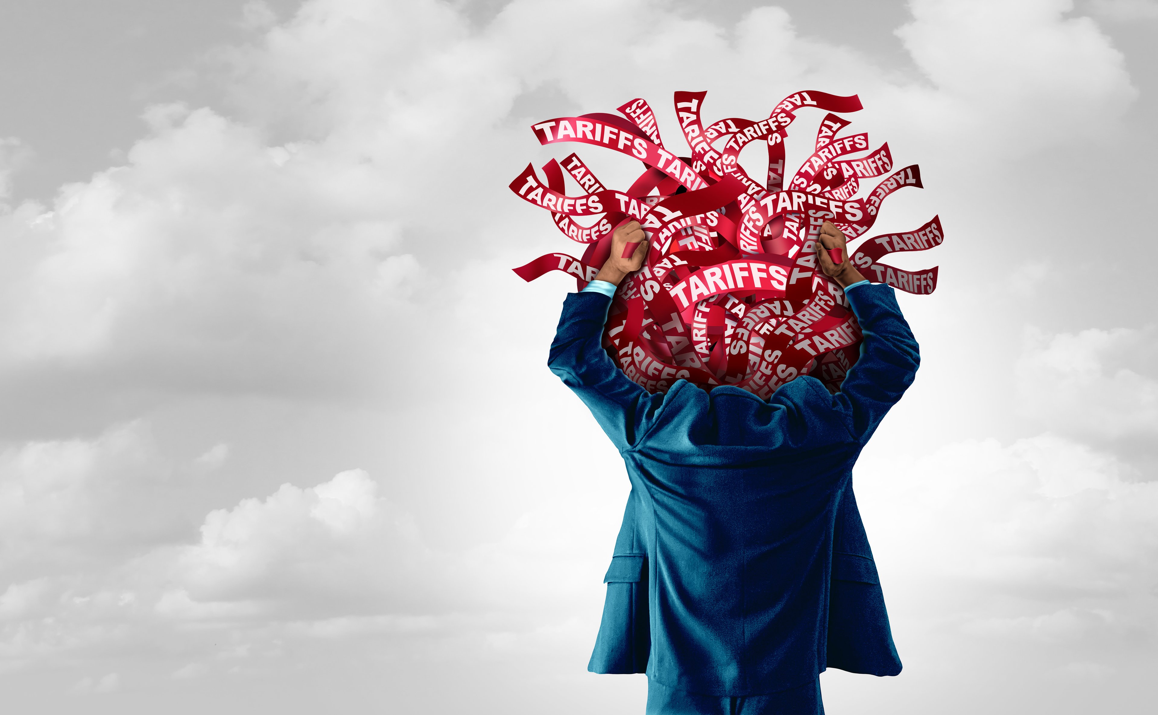 A person holding hands up with many red banners with "Tariffs" printed on them and clouds in the background.