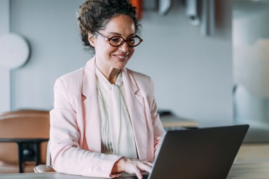 Professional_smiling_while_looking_at_a_laptop