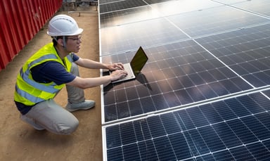 Person using a laptop on top of a solar panel