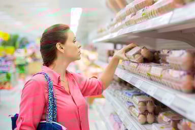 Person shopping in a grocery store for eggs