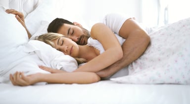 couple sleeping cuddling in bed