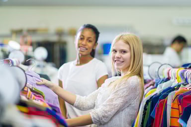 shoppers looking through clothing rack