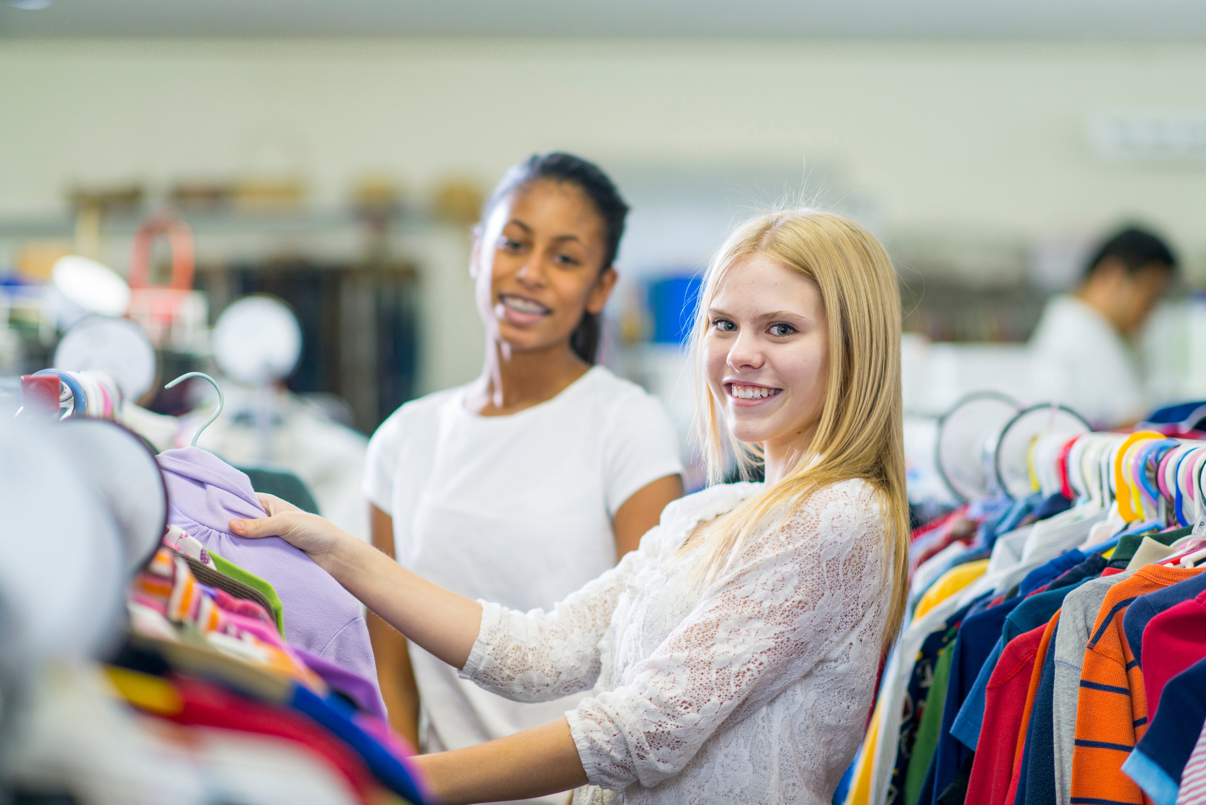 shoppers looking through clothing rack