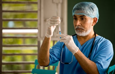 doctor aspirates vaccine into syringe