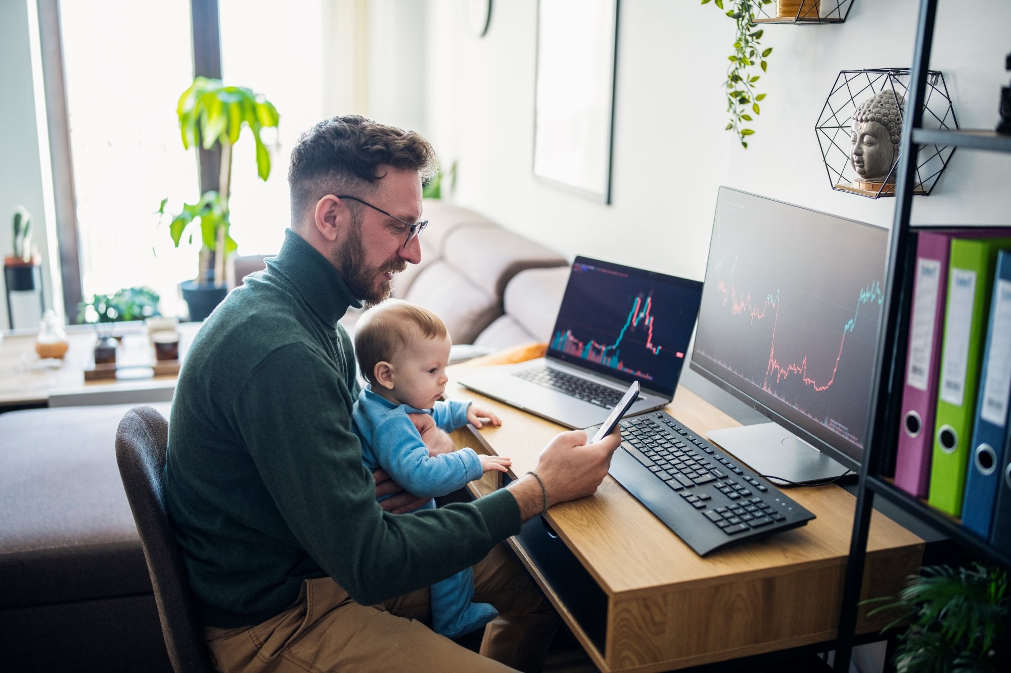 Person looking at stock charts with a child.