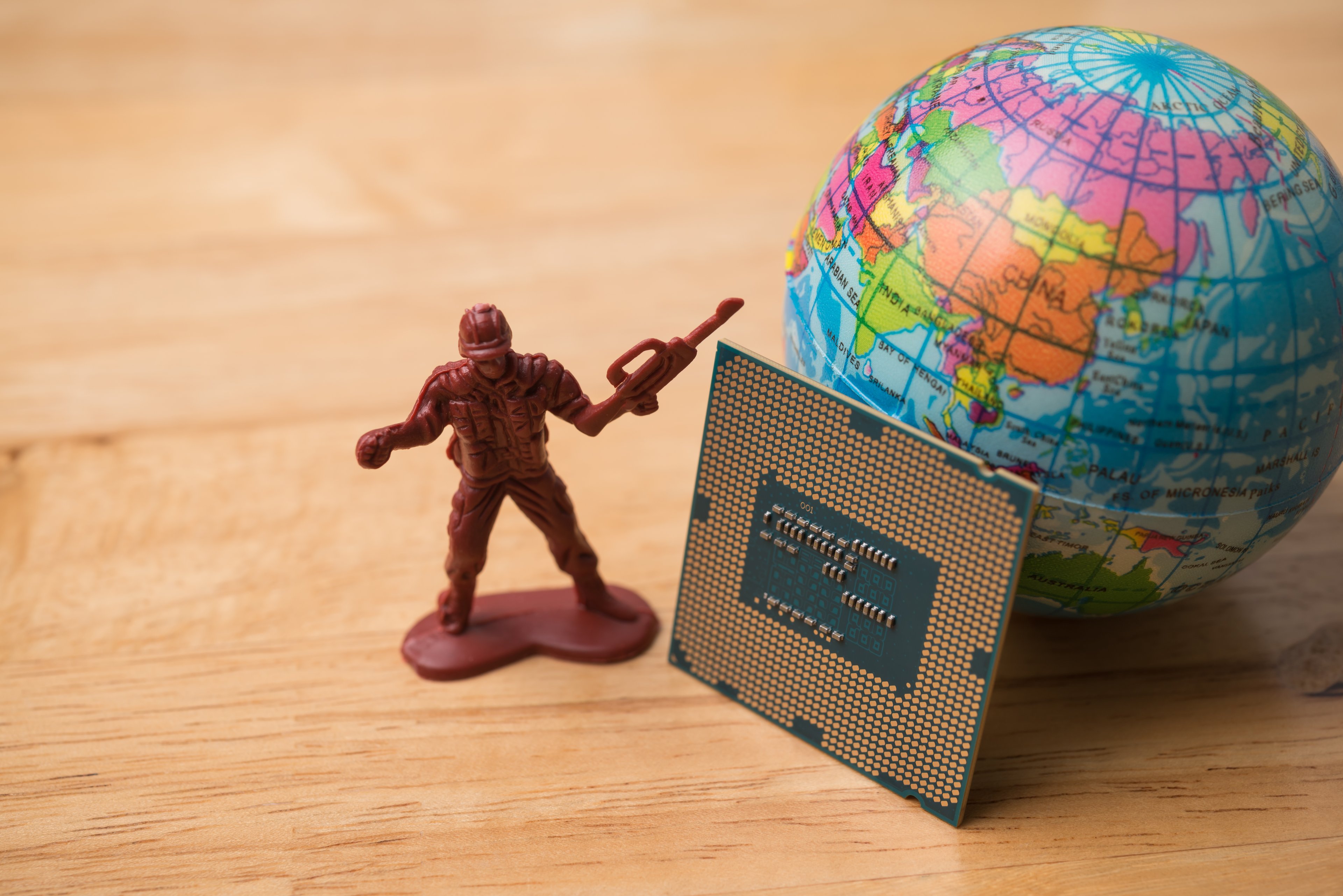 a semiconductor near a toy solider and a globe