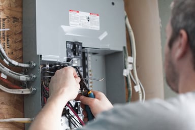 electrician fixing wiring fuse box