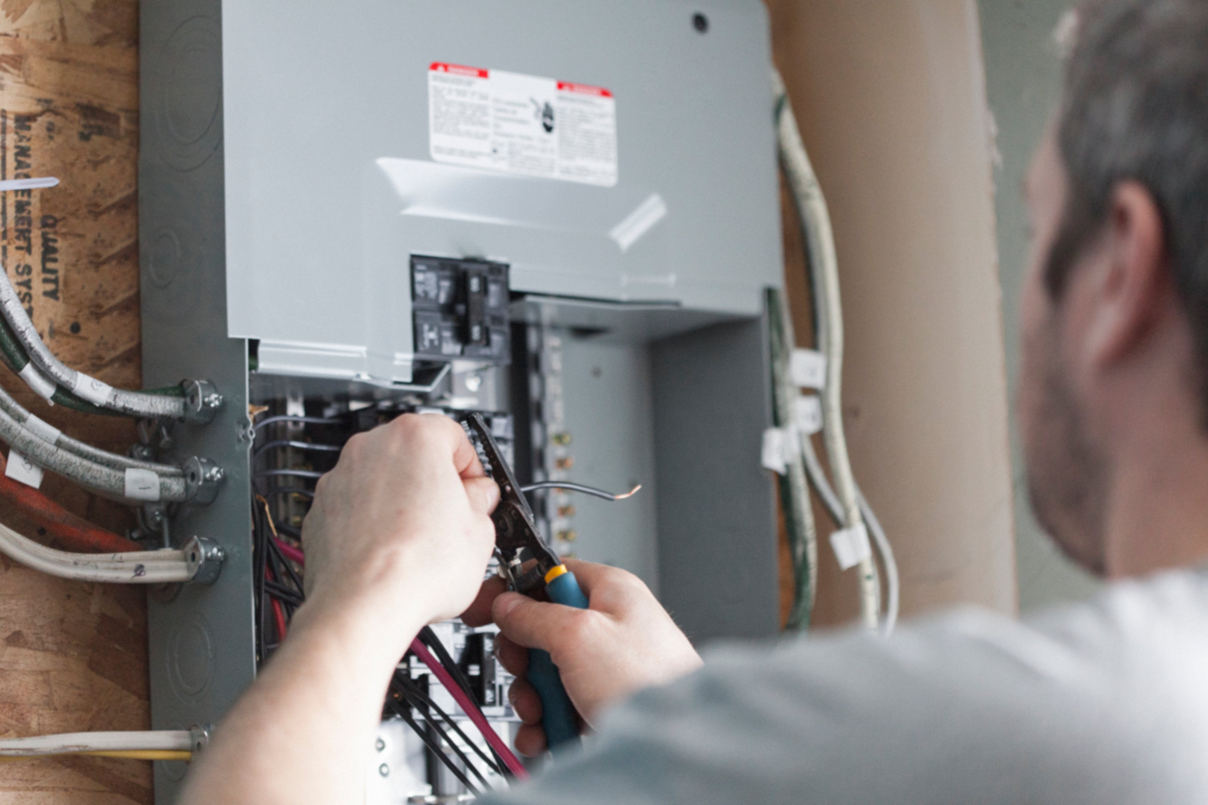 electrician fixing wiring fuse box