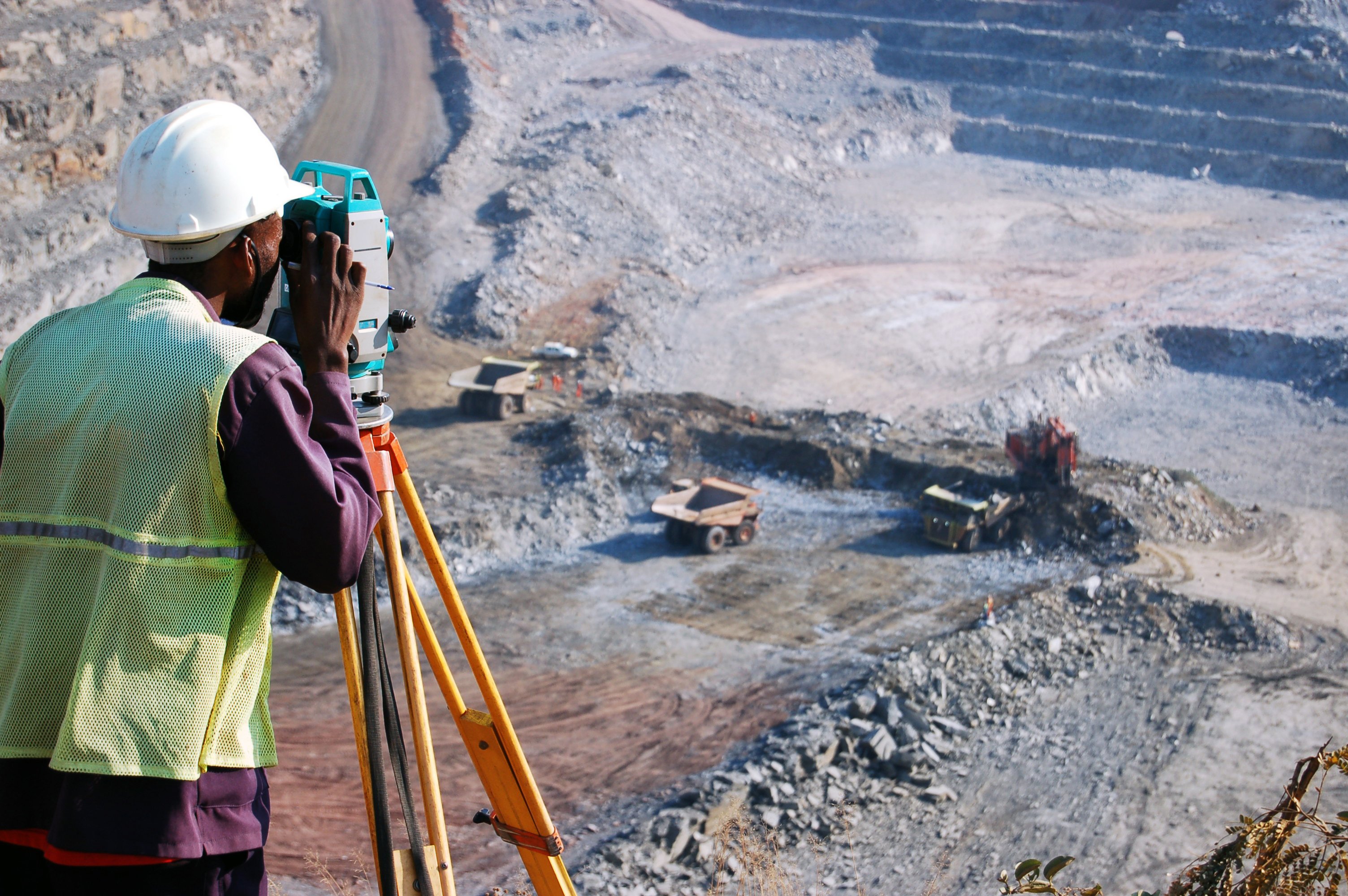 A surveyor works at an open pit mine.