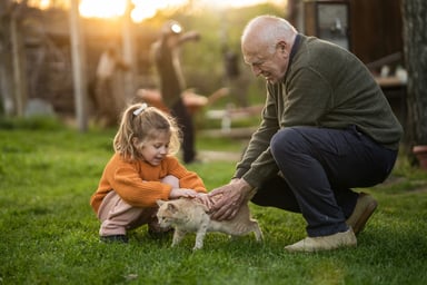 Senior and child petting cat