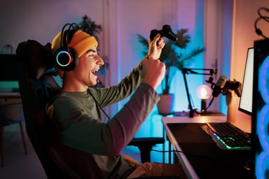 A teen cheering while playing on the computer