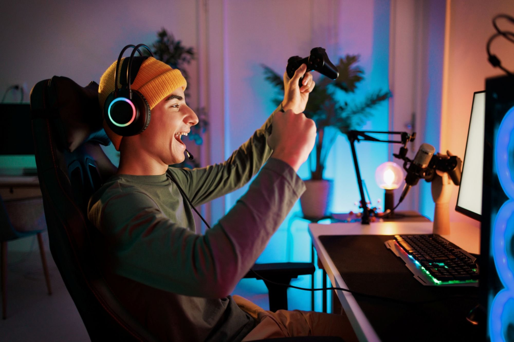 A teen cheering while playing on the computer