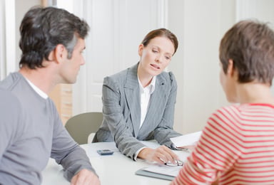 Three people look at financial documents