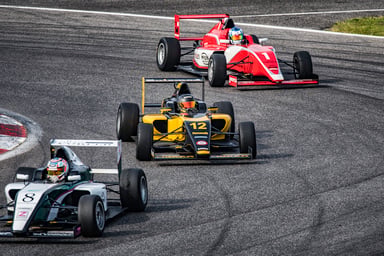 3 race cars circling a track.