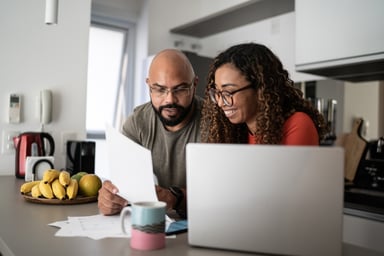 two investors consult papers and laptop