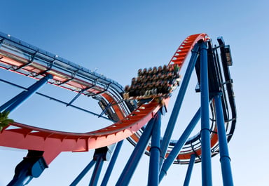 Rollercoaster car full of riders, moving very fast.