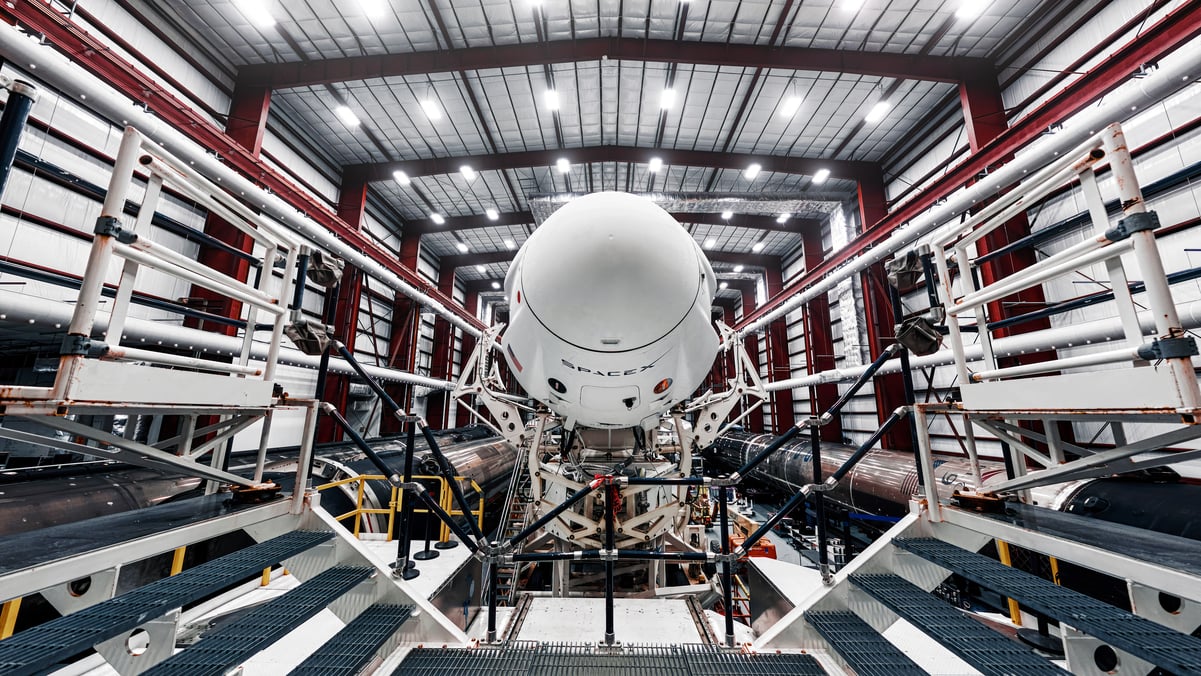 SpaceX rocket under construction in enclosed factory.