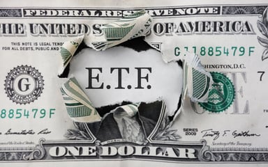 A dollar bill with ETF written behind it.