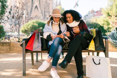 2 people with shopping bags and cellphones