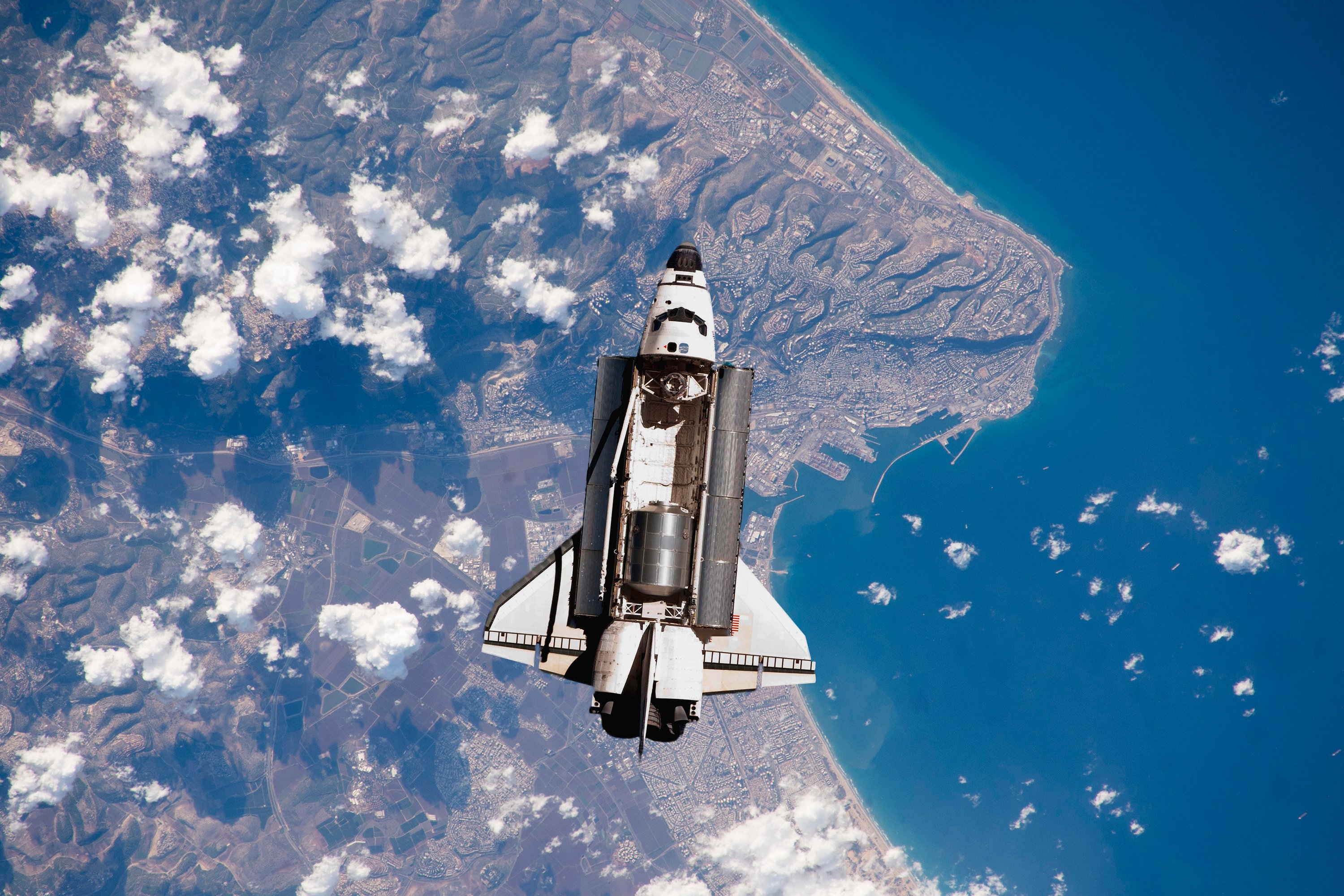 A rocket flies in space, showing the earth beneath it. 
