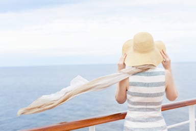 a passenger on a cruise ship looks at ocean 