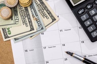 Dollar bills and coins on a calendar