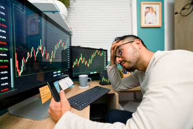 investor facepalms while looking at chart