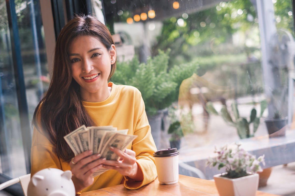 GettyImages-woman cash piggy bank