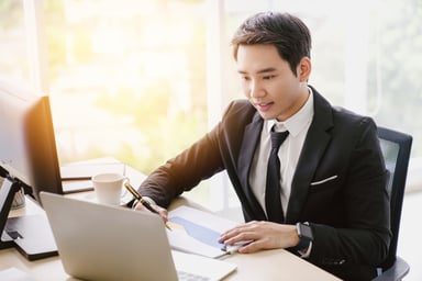Businessman with a chart looking at his computer.