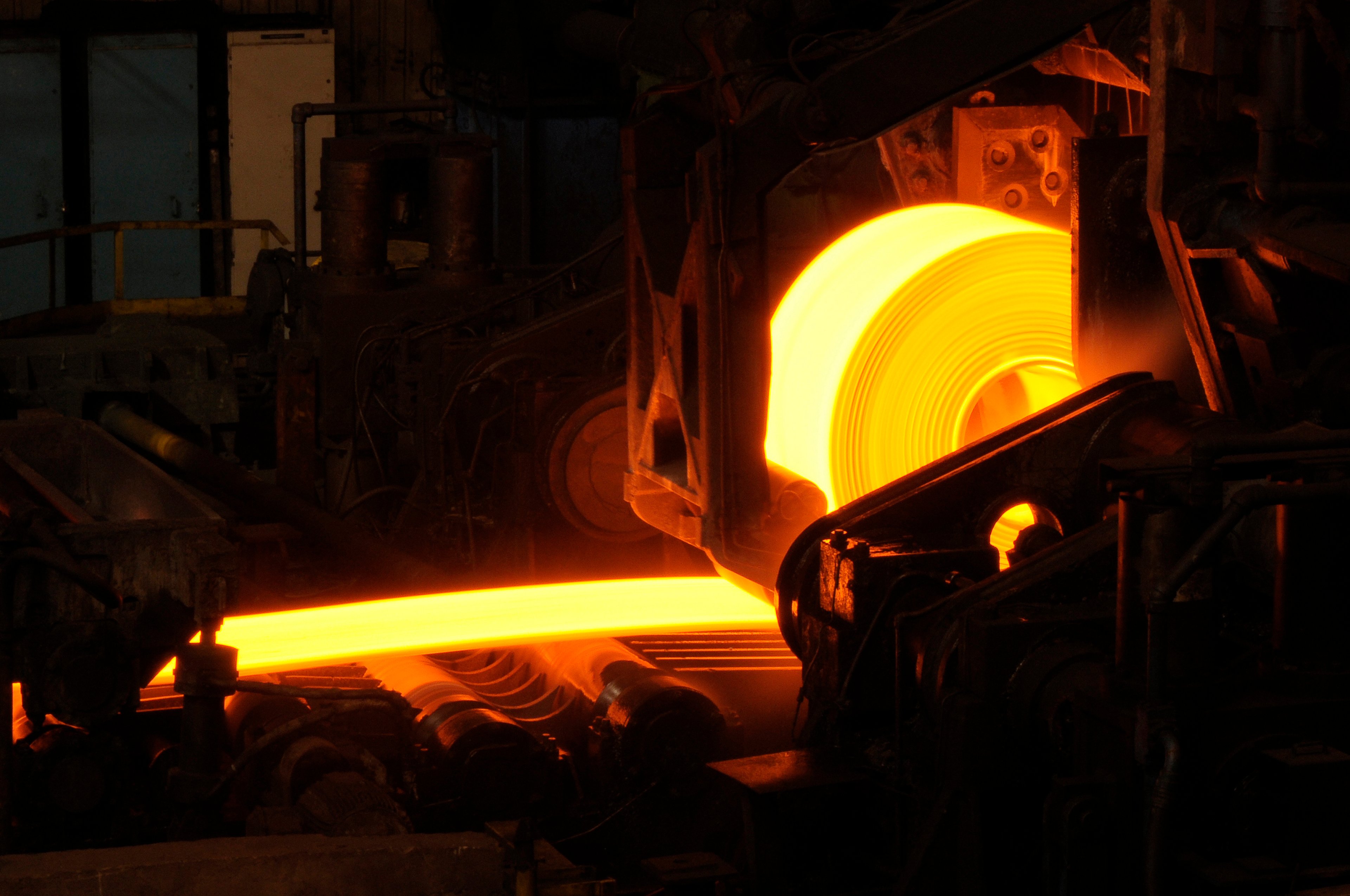 red hot glowing steel coil wrapping on a mandrel in a hot mill. 