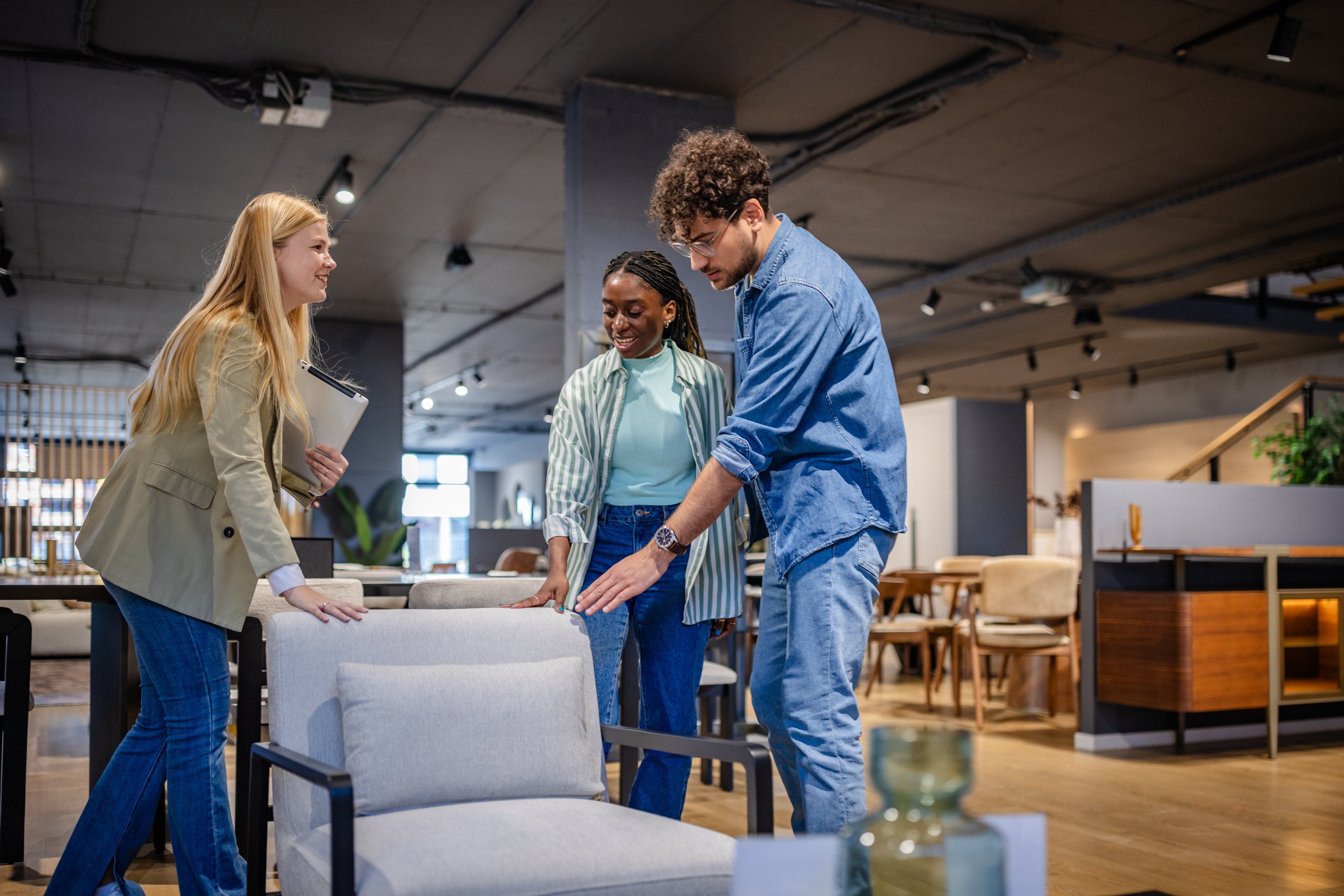 Three people inspecting a chair at a retail store