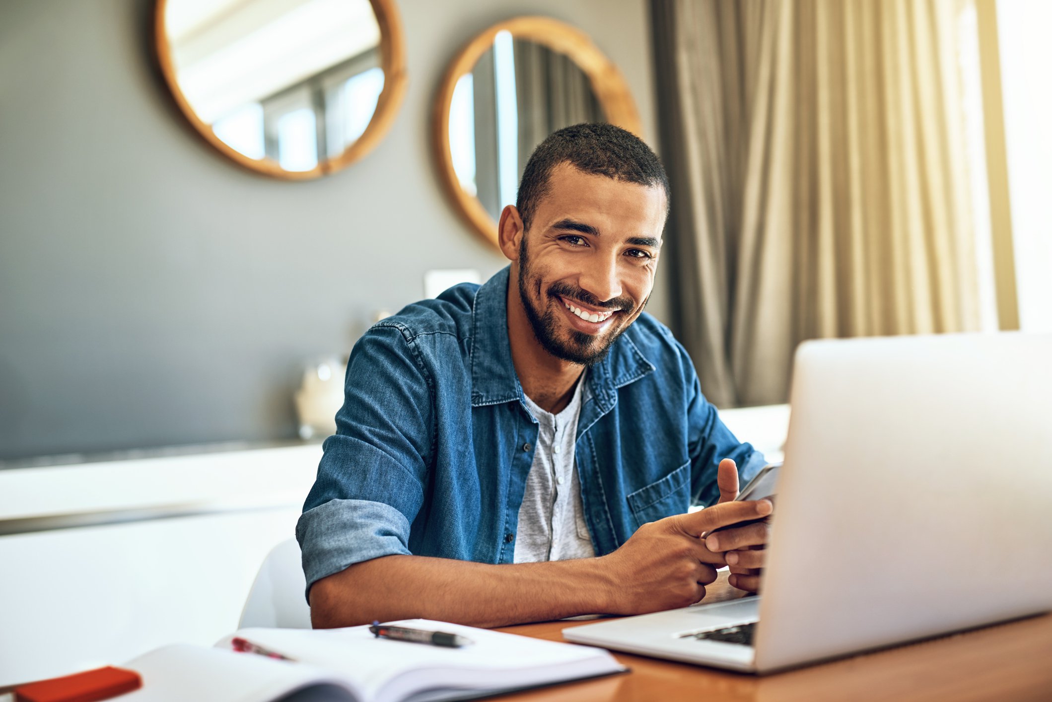 Smiling man in front of computer at home.
