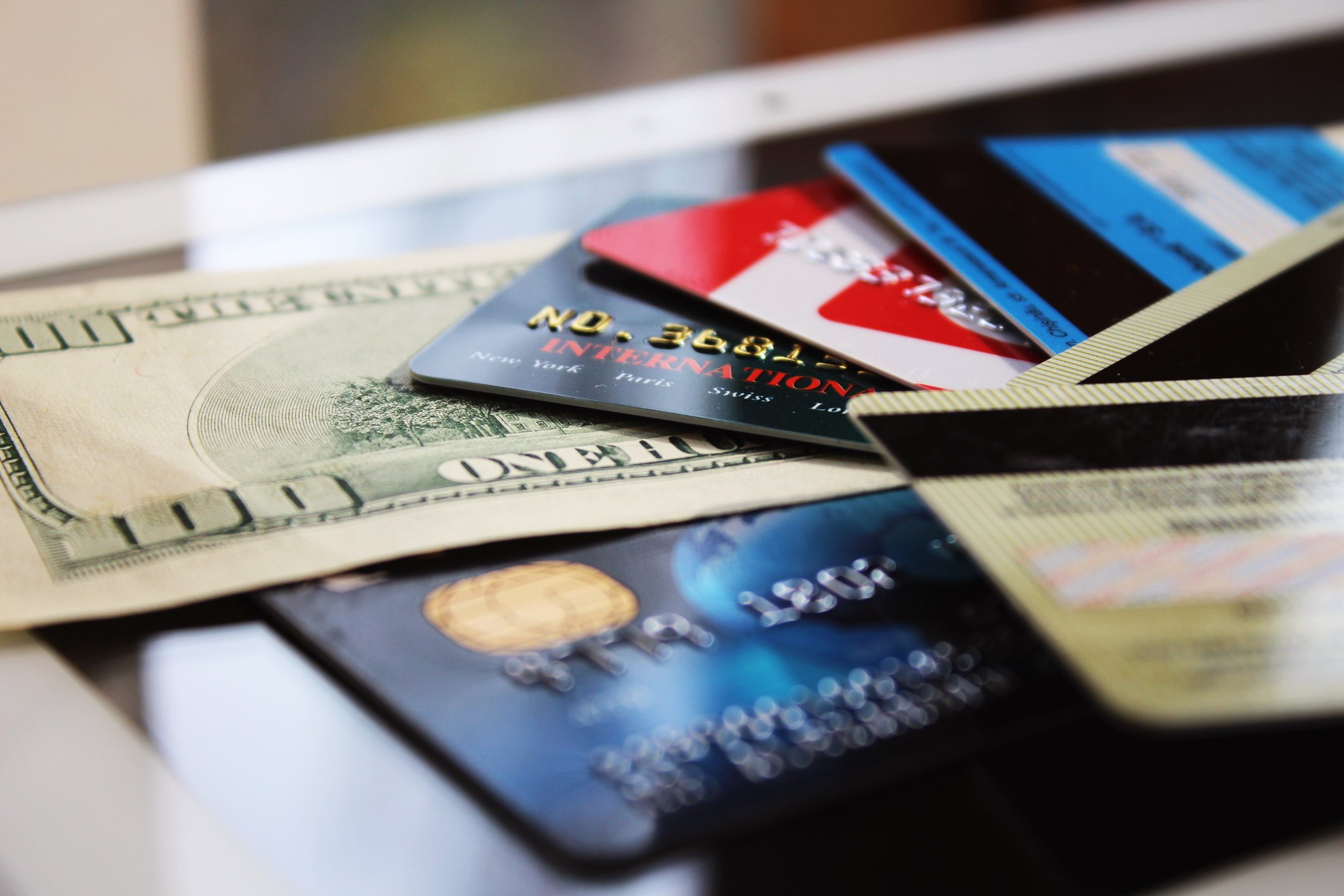Messy pile of credit cards with a hundred dollar bill among them