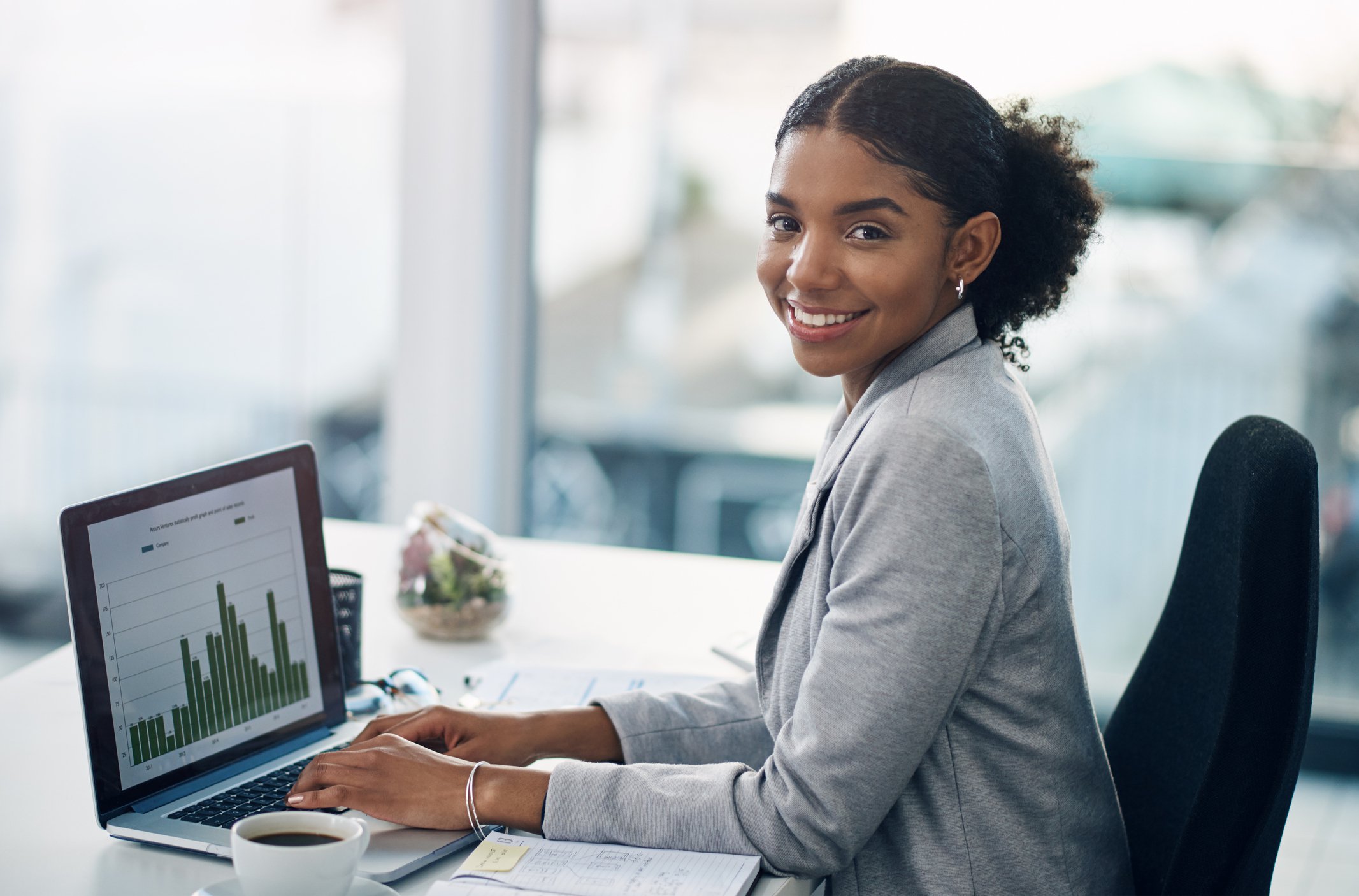 Woman with laptop showing bar chart.