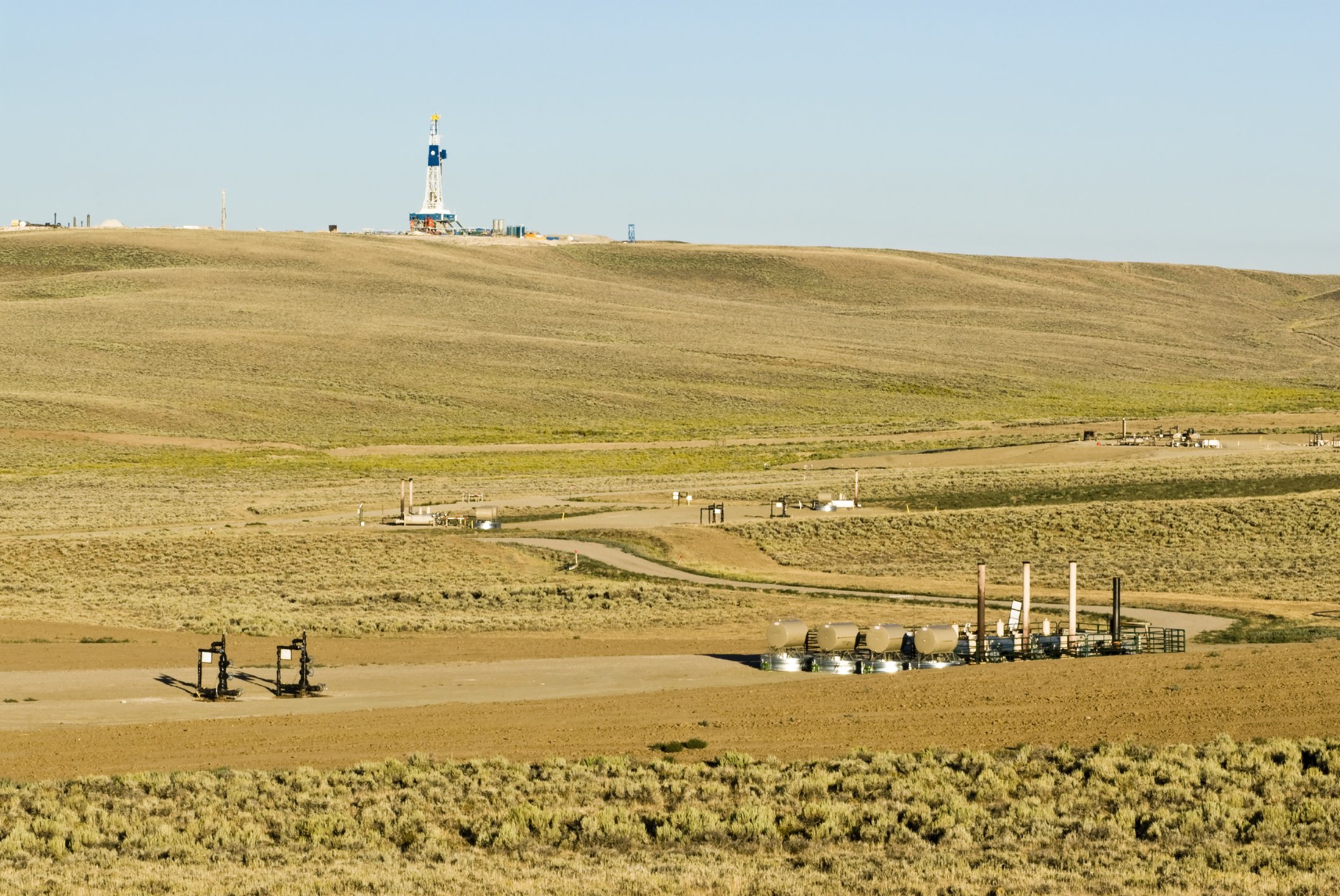 A natural gas field with a drilling rig.