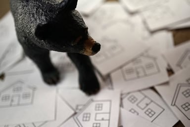 Bear figure on top of cards with houses on them.jpg