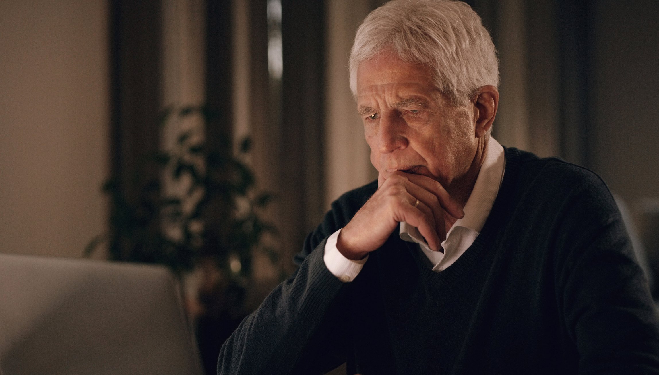 Senior man looking at laptop with serious expression