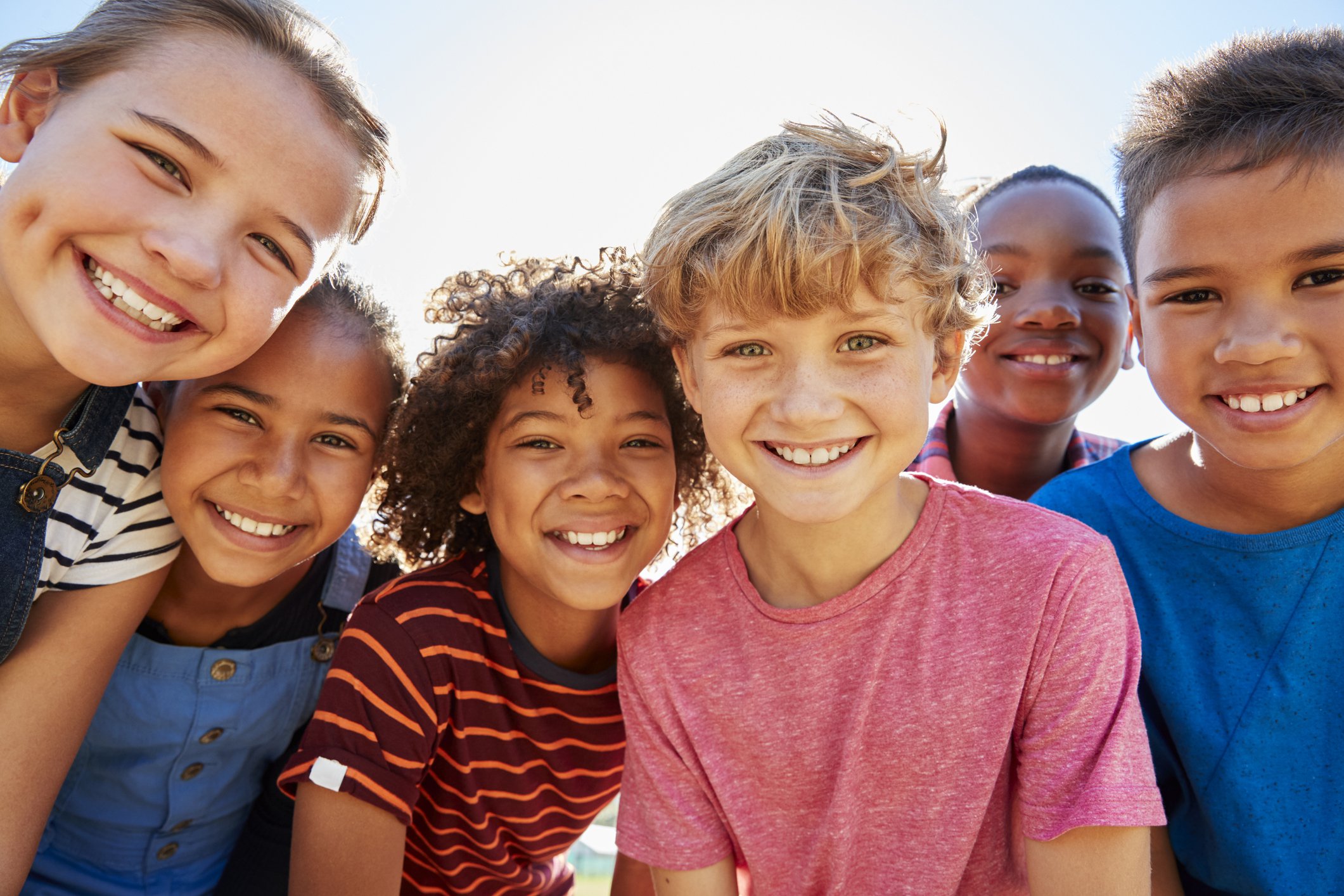 group of children standing shoulder to shoulder and smiling
