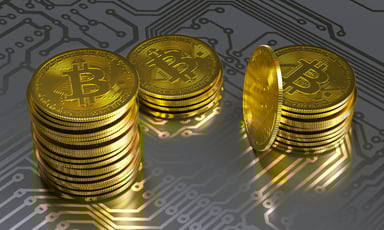 Stacks of physical gold coins marked with the Bitcoin B