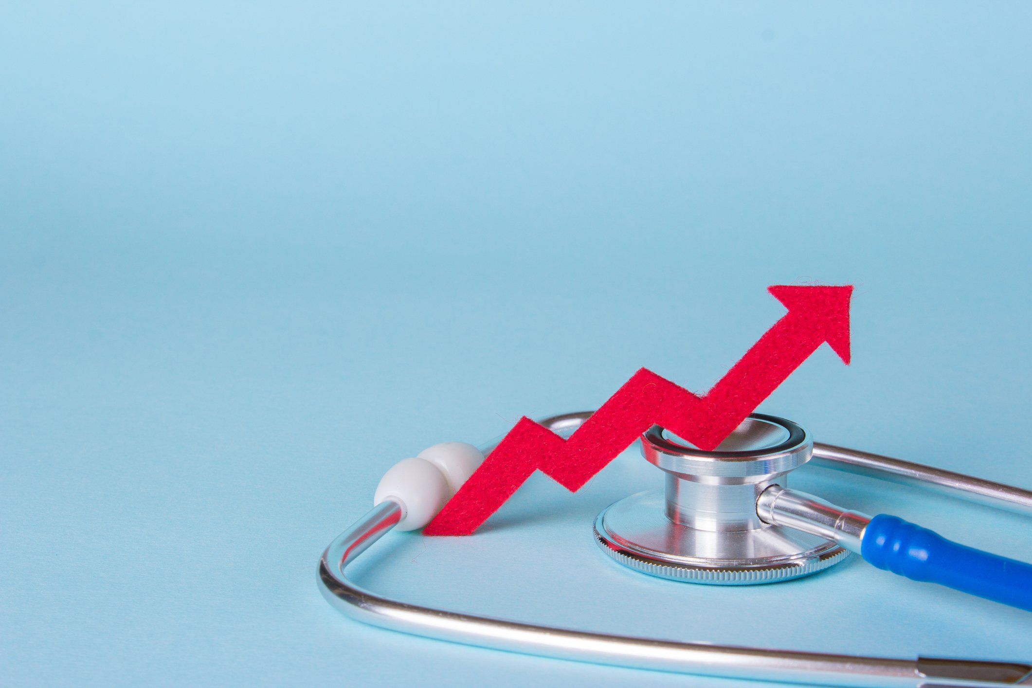A red upward pointing line sits on top of a stethoscope.