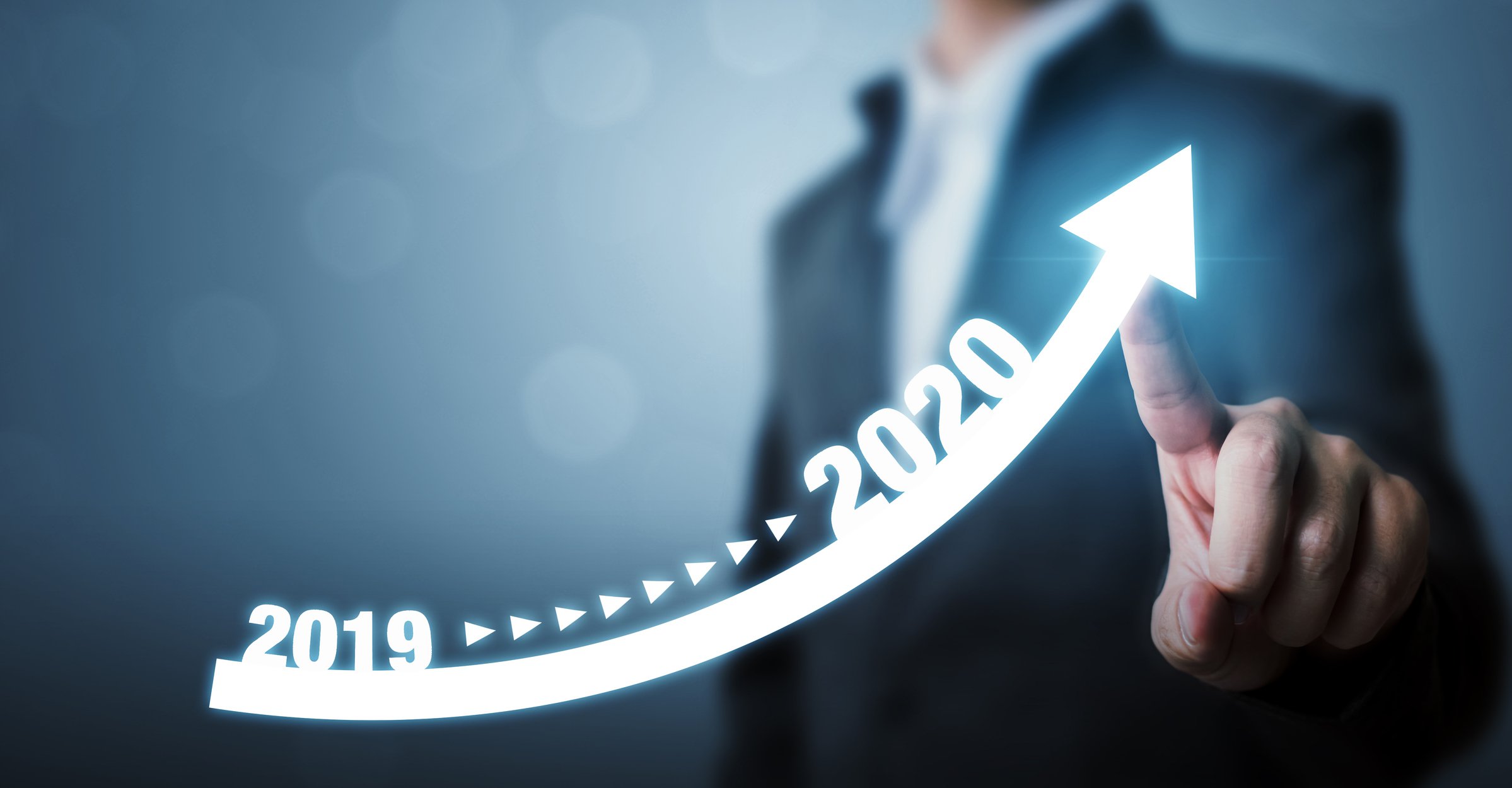 Man pointing to arrow moving up from 2019 to 2020