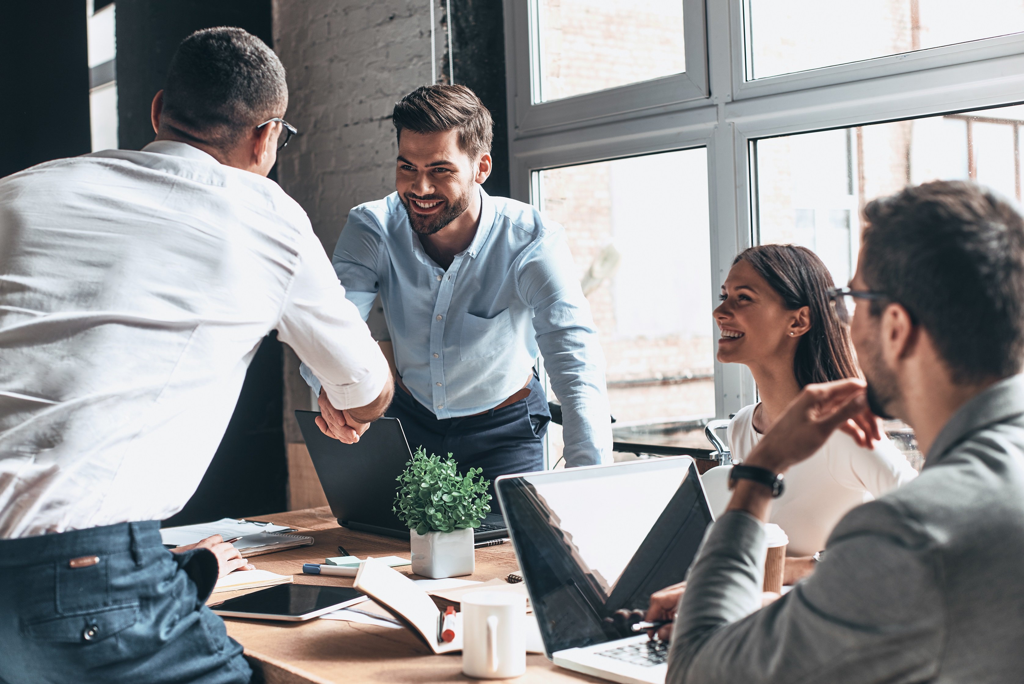 A group of young professionals interact around a table.
