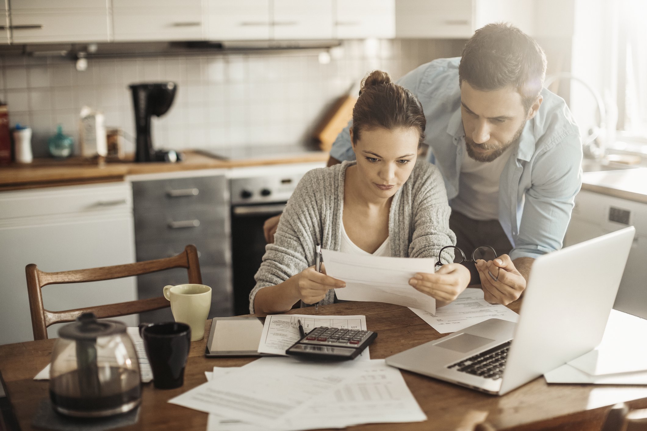 Couple in kitchen reviewing paperwork.