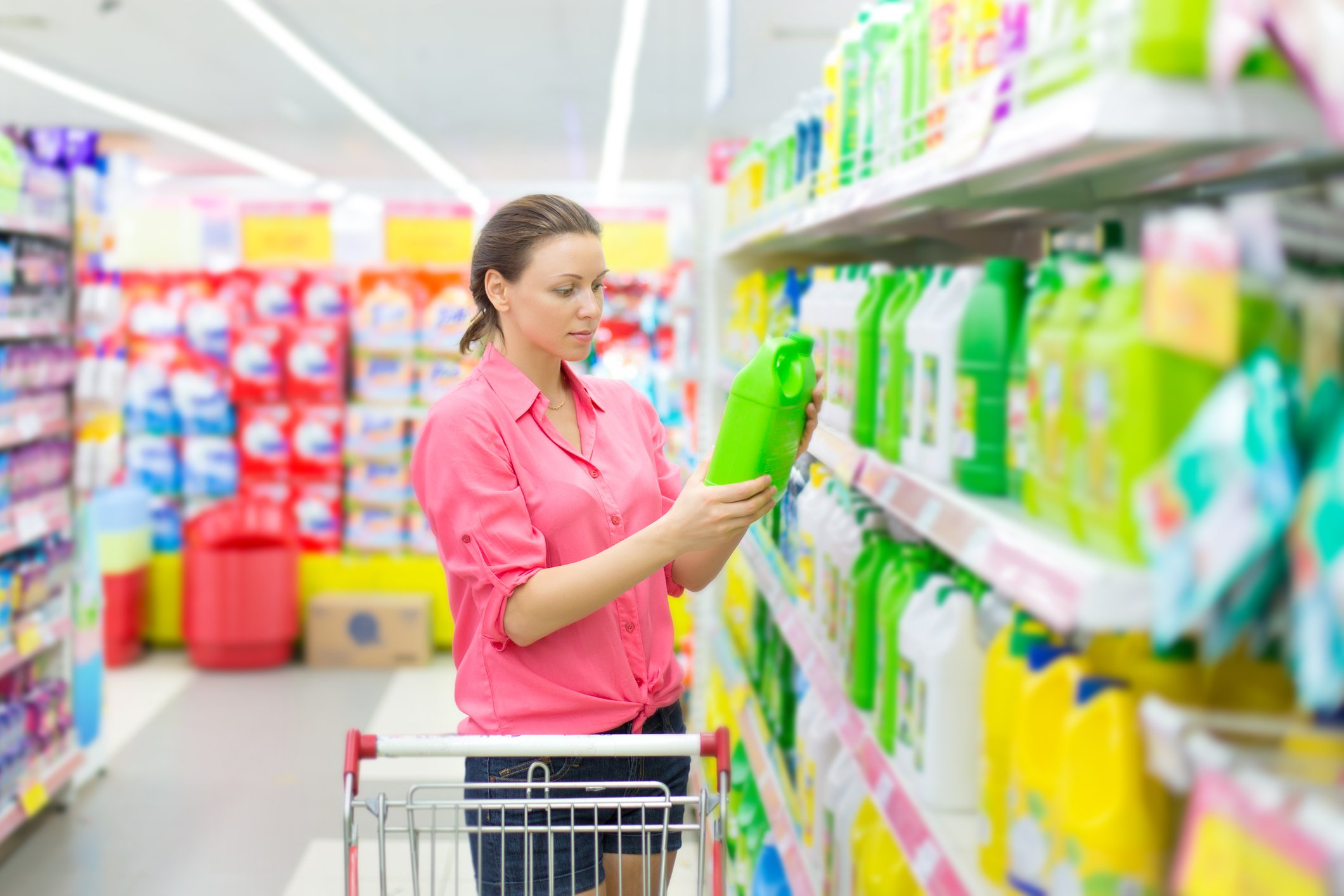 Person looking at laundry detergent while shopping in supermarket.