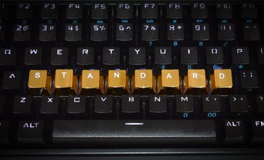 Keyboard with letters rearranged spelling out "STANDARD" in gold letters.