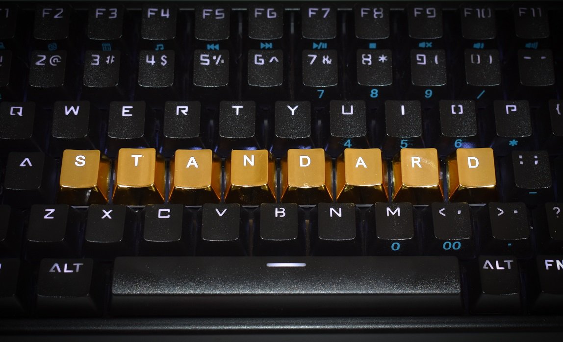 Keyboard with letters rearranged spelling out "STANDARD" in gold letters.
