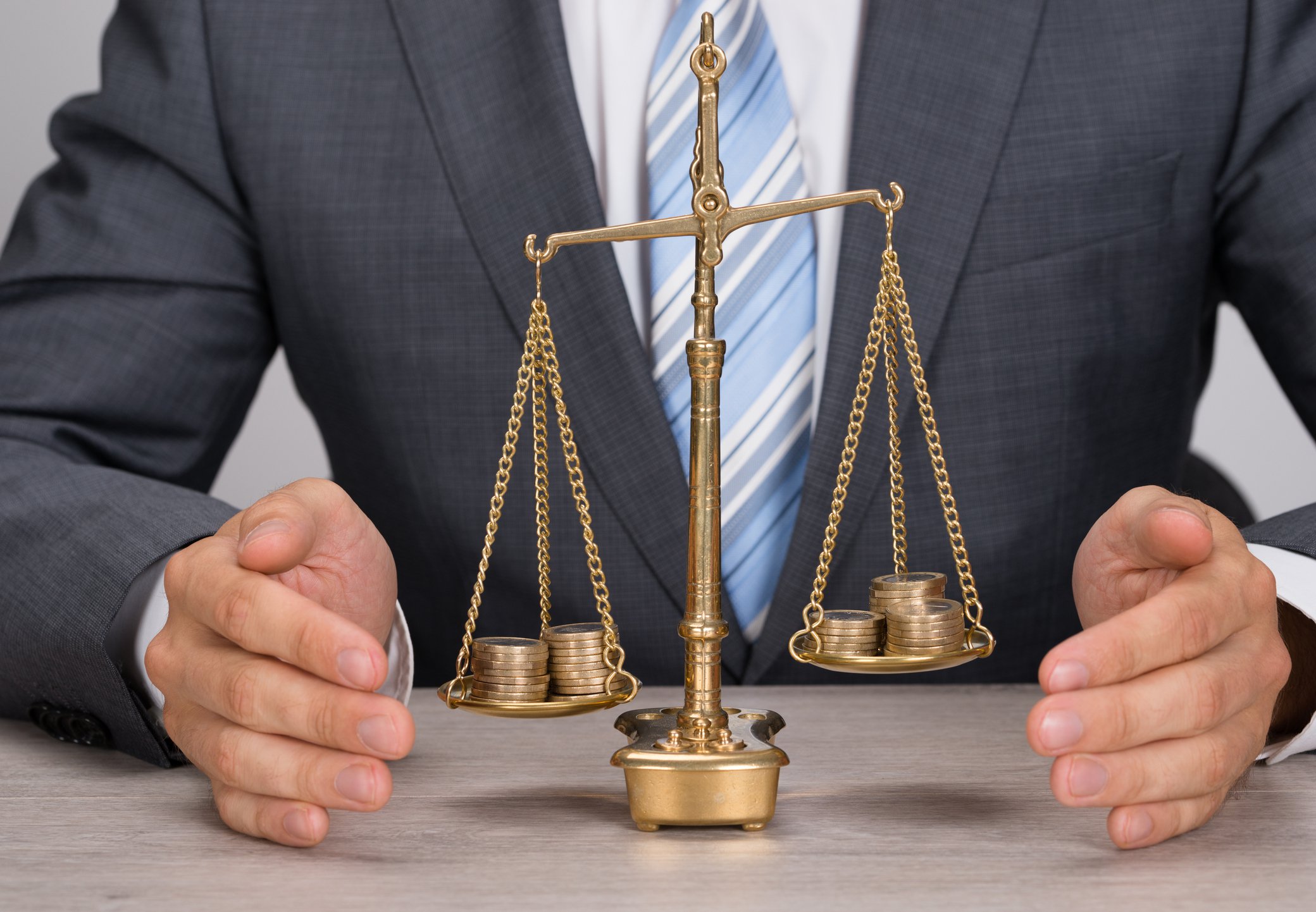 Businessman with scale weighing coins