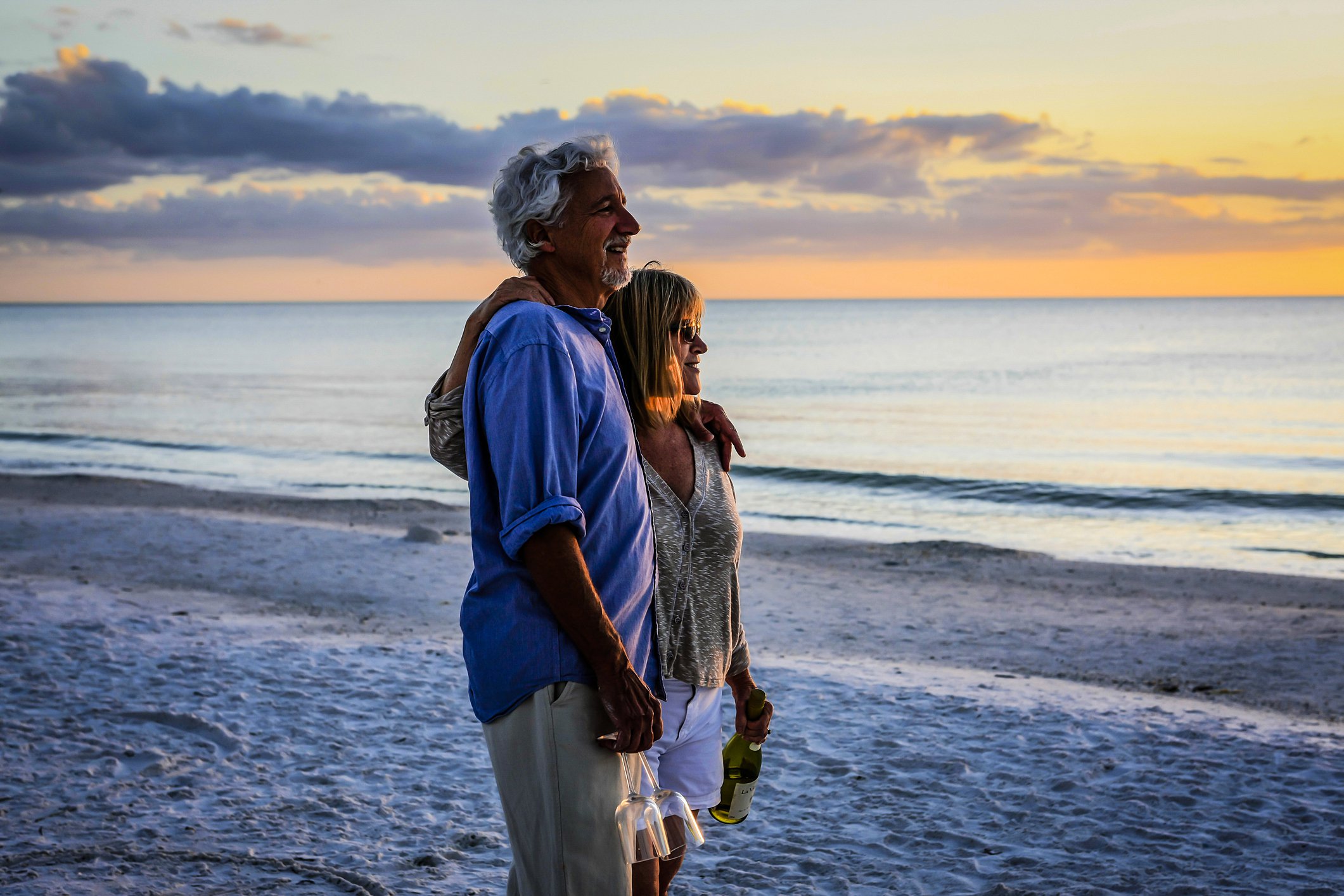 An older couple on the beach at sunset
