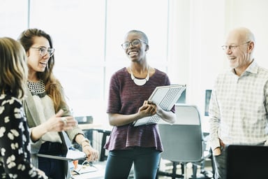 Co-workers smiling and standing together in an office