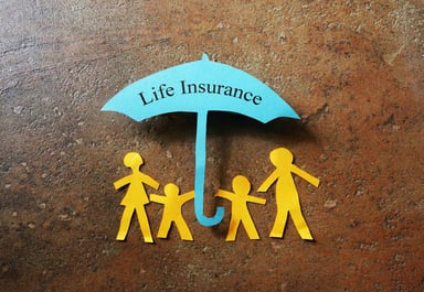 A paper cutout family under an umbrella that reads life insurance.